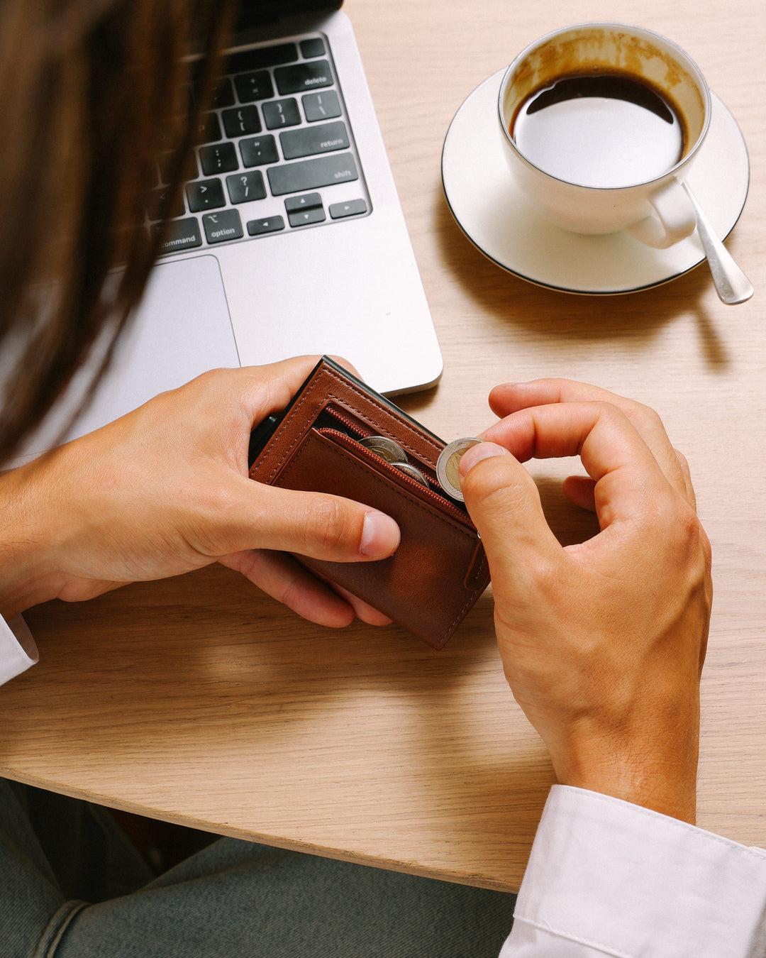 man aan tafel met bruine pasjeshouder